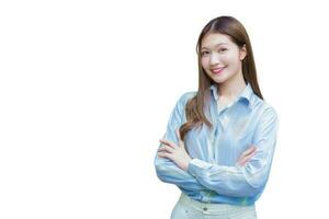 la donna lavoratrice asiatica professionista che ha i capelli lunghi indossa una camicia blu mentre incrocia il braccio e sorride felicemente su sfondo bianco. foto