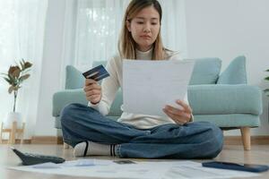 stressato e mal di testa asiatico donna con grande fatture o fatture no i soldi per pagare per spese e credito carta debito. carenza, finanziario i problemi, mutuo, prestito, fallimento, fallito, povero, vuoto portafoglio foto