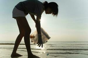 Salva acqua. volontario raccogliere su spazzatura spazzatura a il spiaggia e plastica bottiglie siamo difficile decomporsi impedire danno acquatico vita. terra, ambiente, greening pianeta, ridurre globale riscaldamento, Salva mondo foto