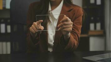 il ritratto di una giovane donna asiatica libera professionista sta lavorando sul tablet del computer in un ufficio moderno. fare un rapporto di analisi contabile dati di investimento immobiliare, concetto di sistemi finanziari e fiscali. foto