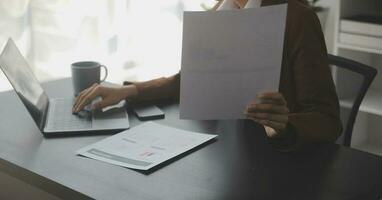 il ritratto di una giovane donna asiatica libera professionista sta lavorando sul tablet del computer in un ufficio moderno. fare un rapporto di analisi contabile dati di investimento immobiliare, concetto di sistemi finanziari e fiscali. foto