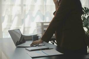 il ritratto di una giovane donna asiatica libera professionista sta lavorando sul tablet del computer in un ufficio moderno. fare un rapporto di analisi contabile dati di investimento immobiliare, concetto di sistemi finanziari e fiscali. foto