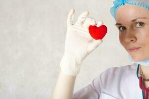 un' rosso felpa cuore nel il mano di un' medico foto