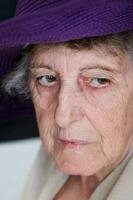 vecchio caucasico donna nel un' viola cappello foto