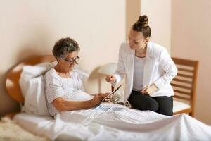 visitare di anziano sociale opera assistente per un vecchio donna foto