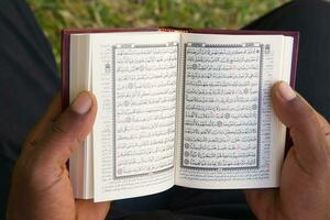 il uomo è lettura il Corano foto