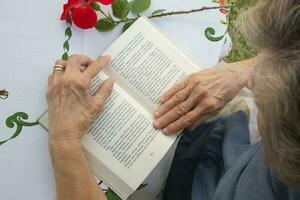 un vecchio donna è lettura un' libro foto