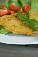 pollo cotoletta con ciliegia pomodori e verde insalata le foglie. foto