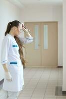 giovane medico soggiorni nel il corridoio di un' ospedale foto