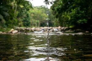spruzzo fatto con un' pietra caduta in il acqua di il cascata nel Paraty nel rio de janeiro foto