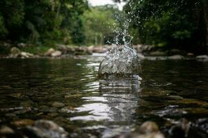 spruzzo fatto con un' pietra caduta in il acqua di il cascata nel Paraty nel rio de janeiro foto