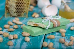 mandorla torrone coperto di pistacchio cioccolato su un' di legno superficie. foto