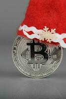 bitcoin nel un' Santa Claus cappello su un' grigio superficie. foto