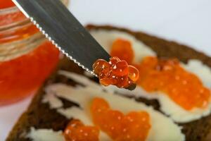 cereale nero pane con burro e rosso caviale. foto