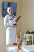 un' giovane sorridente medico vestito nel un' bianca professionale uniforme foto