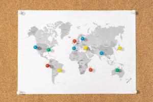 pianificazione viaggio destinazione concetto. puntine su mondo carta geografica su corkboard foto