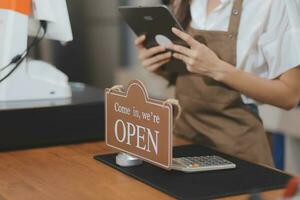 giovane asiatico inizio su piccolo attività commerciale proprietario Aperto il caffè negozio e ristorante. piccolo attività commerciale proprietario e servizio mente. foto