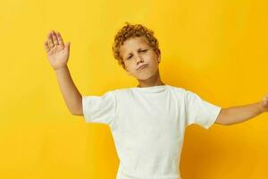 ragazzo con Riccio capelli infanzia in posa giallo sfondo foto