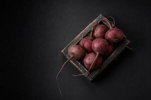 fresco crudo barbabietola nel il modulo di tuberi su un' strutturato calcestruzzo sfondo foto