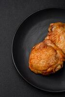 delizioso succoso pollo cosce al forno con sale, spezie e erbe aromatiche nel un' ceramica piatto foto