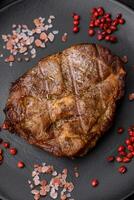 delizioso succoso Maiale o Manzo bistecca grigliato con sale, spezie e erbe aromatiche foto