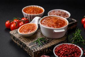 delizioso speziato pomodoro salsa con Pepe, aglio, sale, spezie e erbe aromatiche foto