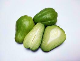 totale chayote e chayote tagliare nel metà, bianca sfondo. foto