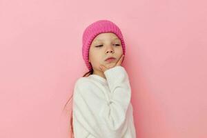 poco ragazza rosa cappello su sua testa in posa rosa sfondo foto