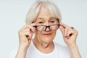 anziano donna visione i problemi con bicchieri isolato sfondo foto