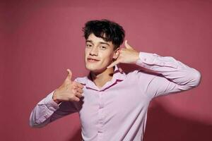 foto di romantico giovane fidanzato nel un' rosa camicia Esprimere a gesti con il suo mani stile di vita inalterato