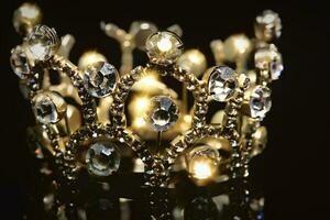 oro corona con brillante pietre su un' nero sfondo. foto