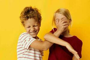 piccolo bambini casuale indossare Giochi divertimento insieme giallo sfondo foto