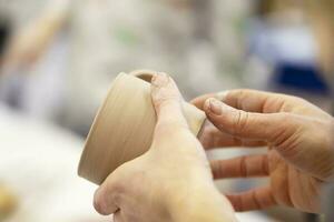 argilla modellismo officina. nel mano è un' appena modellato terracotta tazza. foto