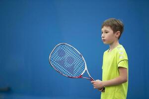 poco ragazzo con un' tennis racchetta. il bambino giochi tennis. foto
