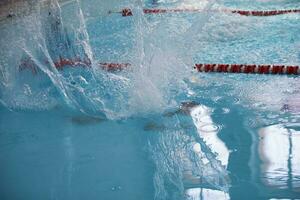 un' uomo è nuoto nel il gli sport piscina foto