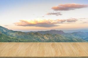 pavimento in legno con sfondo di vista sulle montagne al crepuscolo foto