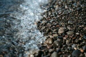 piccolo pietre nel azzurro mare acqua avvicinamento. un' immagine di il mare Surf. oceano Surf tra il rocce. sfondo di il marea. mare schiuma foto