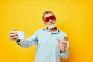 ritratto di contento anziano uomo blu camicie con bicchieri prende un' autoscatto inalterato foto