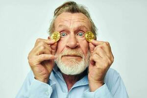ritratto di contento anziano uomo nel un' blu camicia bitcoin su il viso ritagliata Visualizza foto