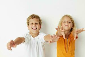 carino prescolastico bambini in posa mano gesto Sorridi casuale indossare isolato sfondo inalterato foto