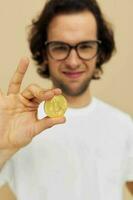 attraente uomo con bicchieri oro bitcoin nel mani stile di vita inalterato foto