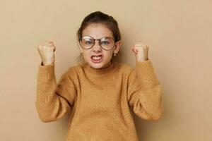 ritratto di contento sorridente bambino ragazza nel un' maglione e in posa bicchieri isolato sfondo foto