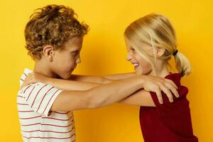 ragazzo e ragazza coccole moda infanzia divertimento giallo sfondo foto