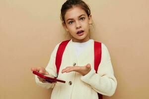 bella giovane ragazza scolara zaino Telefono nel mano infanzia inalterato foto