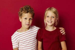 carino elegante bambini sorridente e in posa nel casuale Abiti contro isolato sfondo foto