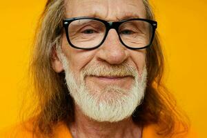 anziano dai capelli grigi uomo con bicchieri viso avvicinamento giallo sfondo foto