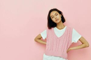 bellissimo ragazza con corto capelli e un' rosa maglione isolato sfondo foto