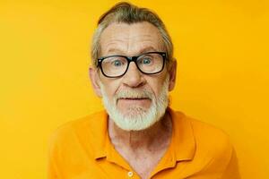 ritratto di contento anziano uomo con un' grigio barba nel bicchieri ritagliata Visualizza foto