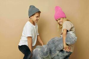 carino elegante bambini nel cappelli con un' orsacchiotto orso amicizia stile di vita inalterato foto