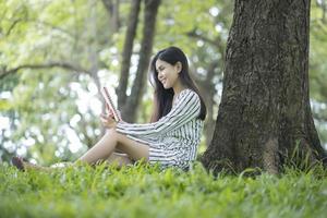 donna attraente che legge un libro nel parco foto